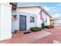 Gray front door with brick walkway and landscaping at 3837 W Port Au Prince Ln, Phoenix, AZ 85053