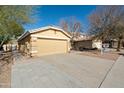 House exterior showcasing a two-car garage and a well-maintained front yard at 12000 W Bloomfield Rd, El Mirage, AZ 85335