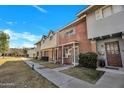 Townhome with brick and siding exterior, and a walkway leading to the entrance at 1387 N 44Th St, Phoenix, AZ 85008