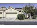 House exterior featuring a tan facade, two-car garage, and mature trees at 1548 E Melrose Dr, Casa Grande, AZ 85122