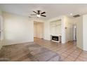 Living room with fireplace, tile floors, and neutral decor at 16148 W Starlight Dr, Surprise, AZ 85374