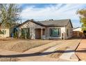 Charming single-story home with desert landscaping, and a long driveway under a blue sky at 1934 E Brill St, Phoenix, AZ 85006