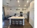 Modern kitchen with white cabinetry, stainless steel appliances, pendant lighting, and a center island with bar seating at 20490 N 78Th Way, Scottsdale, AZ 85255