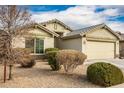 Tan house with a two-car garage and landscaped yard at 25740 W Watkins St, Buckeye, AZ 85326