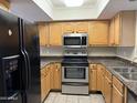 Modern kitchen with wood cabinets, granite countertops, and stainless steel appliances at 3405 W Danbury Dr # D121, Phoenix, AZ 85053