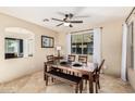 Cozy dining room with a wooden table, bench, and a modern ceiling fan at 42531 W Chisholm Dr, Maricopa, AZ 85138