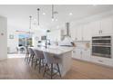 Modern white kitchen with an island, stainless steel appliances, and white cabinetry at 4752 S Orbit Ave, Mesa, AZ 85212