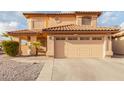 Two-story house with tan exterior, tile roof, and two-car garage at 5766 W Brown St, Glendale, AZ 85302