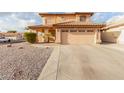 Two-story house with tan exterior, tile roof, and a two-car garage at 5766 W Brown St, Glendale, AZ 85302