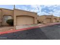 Row of tan stucco condos with attached garages at 625 N Hamilton St # 11, Chandler, AZ 85225