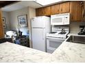 Bright kitchen features white appliances and wood cabinets at 867 E Lancaster Cir, Florence, AZ 85132