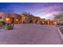 Stunning estate with large windows and a brick driveway in a desert setting at 10473 E Greythorn Dr, Scottsdale, AZ 85262