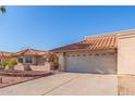 Tan colored house with tile roof and a two-car garage at 10662 N 33Rd Pl, Phoenix, AZ 85028