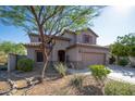 Two-story house with a beige exterior, two-car garage, and landscaping at 10789 W Yearling Rd, Peoria, AZ 85383