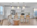 Modern kitchen with white cabinets, quartz countertops, and gold accents at 17574 W Cardinal Dr, Goodyear, AZ 85338