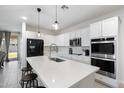 Modern kitchen with white cabinets, quartz countertops, and stainless steel appliances at 17923 W Louise Dr, Surprise, AZ 85387