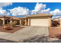 One-story house with beige exterior, attached garage, and landscaped front yard at 25700 W St James Ave, Buckeye, AZ 85326