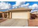 One-story house with beige exterior, attached garage, and landscaped front yard at 25700 W St James Ave, Buckeye, AZ 85326