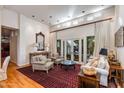 Inviting living room with high ceilings, white walls, a decorative rug, hardwood floors, and patio access at 3137 E Maryland Ave, Phoenix, AZ 85016