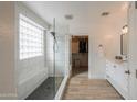 Bright bathroom with a glass-enclosed shower, bench, modern fixtures, and an open doorway to a walk-in closet at 35598 N Murray Grey Dr, San Tan Valley, AZ 85143