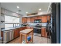 Well-lit kitchen boasts stainless steel appliances, wood cabinetry, and an island with a butcher block top at 35598 N Murray Grey Dr, San Tan Valley, AZ 85143