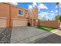 Tan two-story townhome with a two-car garage and small lawn at 3703 E Mitchell Dr, Phoenix, AZ 85018