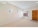 Bright and airy living room with neutral carpeting and wood door at 3703 E Mitchell Dr, Phoenix, AZ 85018