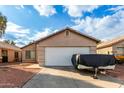 Tan house with white garage door and landscaping at 4510 N 84Th Ave, Phoenix, AZ 85037