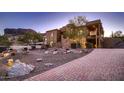 Brick paver driveway leading to a beautiful two-story home with desert landscaping at 4590 S Gold Canyon Dr, Gold Canyon, AZ 85118