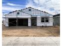 Exterior view of a home under construction, featuring a garage, scaffolding and wrapped in protective material at 46905 W Old Timer Rd, Maricopa, AZ 85139