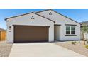 Inviting single-story home featuring stucco exterior, brown trim, desert landscaping, and a two-car garage at 46905 W Old Timer Rd, Maricopa, AZ 85139