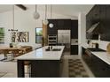 Modern kitchen with dark cabinetry, quartz countertops, and stainless steel appliances at 6727 N 9Th Dr, Phoenix, AZ 85013