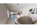 Open concept dining area with view into the kitchen and living room at 9745 W Agora Ln, Tolleson, AZ 85353