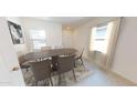 Dining room with an oval wooden table and six beige chairs at 9745 W Agora Ln, Tolleson, AZ 85353