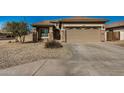 House exterior showcasing a two-car garage and stone accents at 10036 W Parkway Rd, Tolleson, AZ 85353