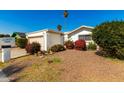 Single-story home with a carport and nicely landscaped front yard at 10436 W Devonshire Ave, Phoenix, AZ 85037