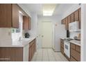 Galley style kitchen with wood cabinets and white appliances at 10737 W Hutton Dr, Sun City, AZ 85351