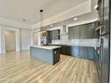 Modern kitchen with gray cabinets, quartz countertops, and stainless steel appliances at 11615 S 211Th Ln, Buckeye, AZ 85326