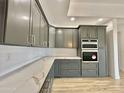 Modern kitchen with gray cabinets and quartz countertops at 11615 S 211Th Ln, Buckeye, AZ 85326