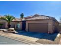 Tan house with tile roof, attached garage, and desert landscaping at 1233 E Redfield Rd, Phoenix, AZ 85022