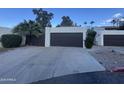 Attached two-car garage with modern door and a long driveway with desert landscape at 1501 S River Dr, Tempe, AZ 85281