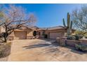 Desert home exterior with large driveway and mature trees at 17353 N 99Th St, Scottsdale, AZ 85255