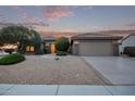 Tan colored house with a two-car garage and gravel landscaping at 17802 N Bridle Ln, Surprise, AZ 85374