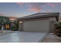 Two-car garage with tan colored doors and stucco exterior at 17802 N Bridle Ln, Surprise, AZ 85374