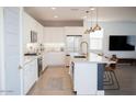 Modern kitchen with white cabinets, quartz countertops, and an island at 21282 E Swan Dr, Queen Creek, AZ 85142