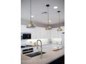 Modern kitchen island with a quartz countertop and gold pendant lighting at 21282 E Swan Dr, Queen Creek, AZ 85142