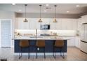 Modern kitchen with white cabinets, a large island, and gold hardware at 21282 E Swan Dr, Queen Creek, AZ 85142