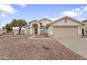 Charming single-story home featuring a well-maintained yard with desert landscaping, neutral color palette, and arched entryway at 2830 S Arroyo Ct, Chandler, AZ 85286