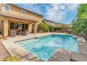 A refreshing backyard pool with an outdoor living space and covered patio at 3501 E Apricot Ln, Gilbert, AZ 85298