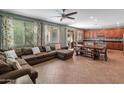 Spacious living room featuring tile floors, a large sectional sofa and ample natural light at 3501 E Apricot Ln, Gilbert, AZ 85298